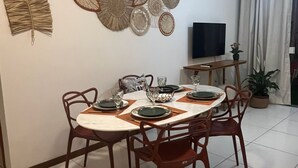 A dining area with a round table set for four, surrounded by wooden chairs. - Vacation Rental for Carnival - Furnished Apartment" "Carnival 2026 (salvador)