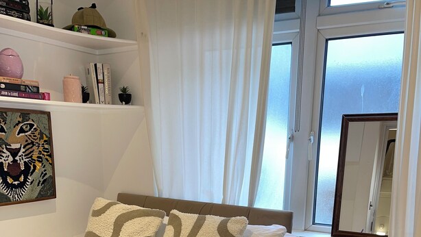 Quarto bem arrumado com uma cama, mesa de cabeceira e criado-mudo.