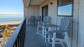 A balcony with a view of the beach, equipped with chairs and a table. - Myrtle Beach Resort RT0715 (Myrtle Beach)