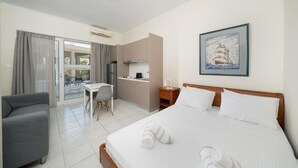 A hotel room with a bed, a desk, a sofa, and a dining area. - Bed & Fligth (Markopoulo Mesogaias)
