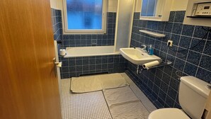 Un baño con bañera, lavabo e inodoro.