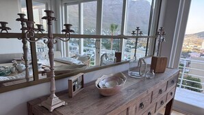 Um console de madeira com um espelho, candelabro e objetos decorativos.