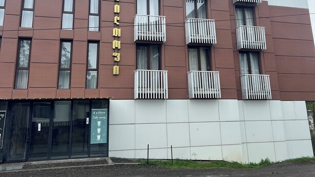 Ein mehrstöckiges Gebäude mit modernem Design, das Balkone und große Fenster aufweist.