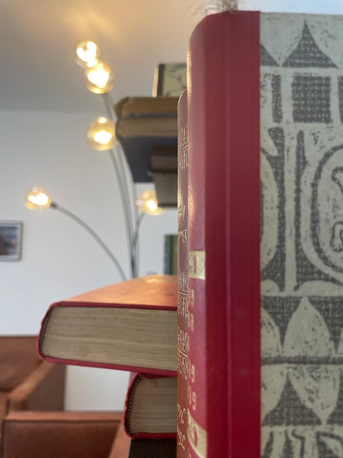 A stack of books with a patterned bookend.