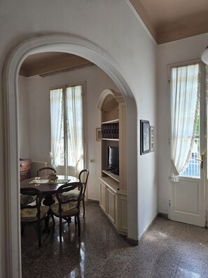 A dining area with a table, chairs, and a television set. - Villa Lauretta detached, 2 steps from the beach (Viareggio)