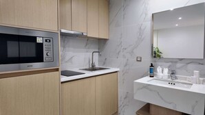 Eine moderne Küche mit eingebauter Mikrowelle, einem Spülbecken und einer Marmor-Spritzschutzwand.