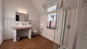 Une salle de bain moderne équipée d’une douche, d’un lavabo et de toilettes.