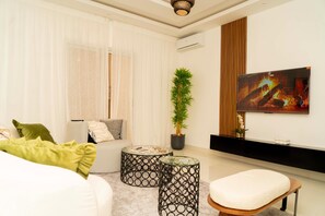 A modern living room with a sofa, two round coffee tables, a potted plant, and a painting on the wall. - Paris Palace - a wonderful 2 bedroom appartement in Dakar (Dakar)