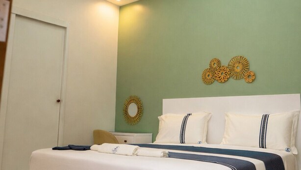 Una camera da letto moderna con un letto, una lampada a soffitto e decorazioni murali.