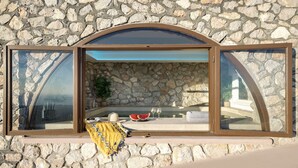 A stone wall with a large arched window overlooking a pool area. - Villa - Sleeps 5 - Private Heated Pool-parking (Pyrgos)
