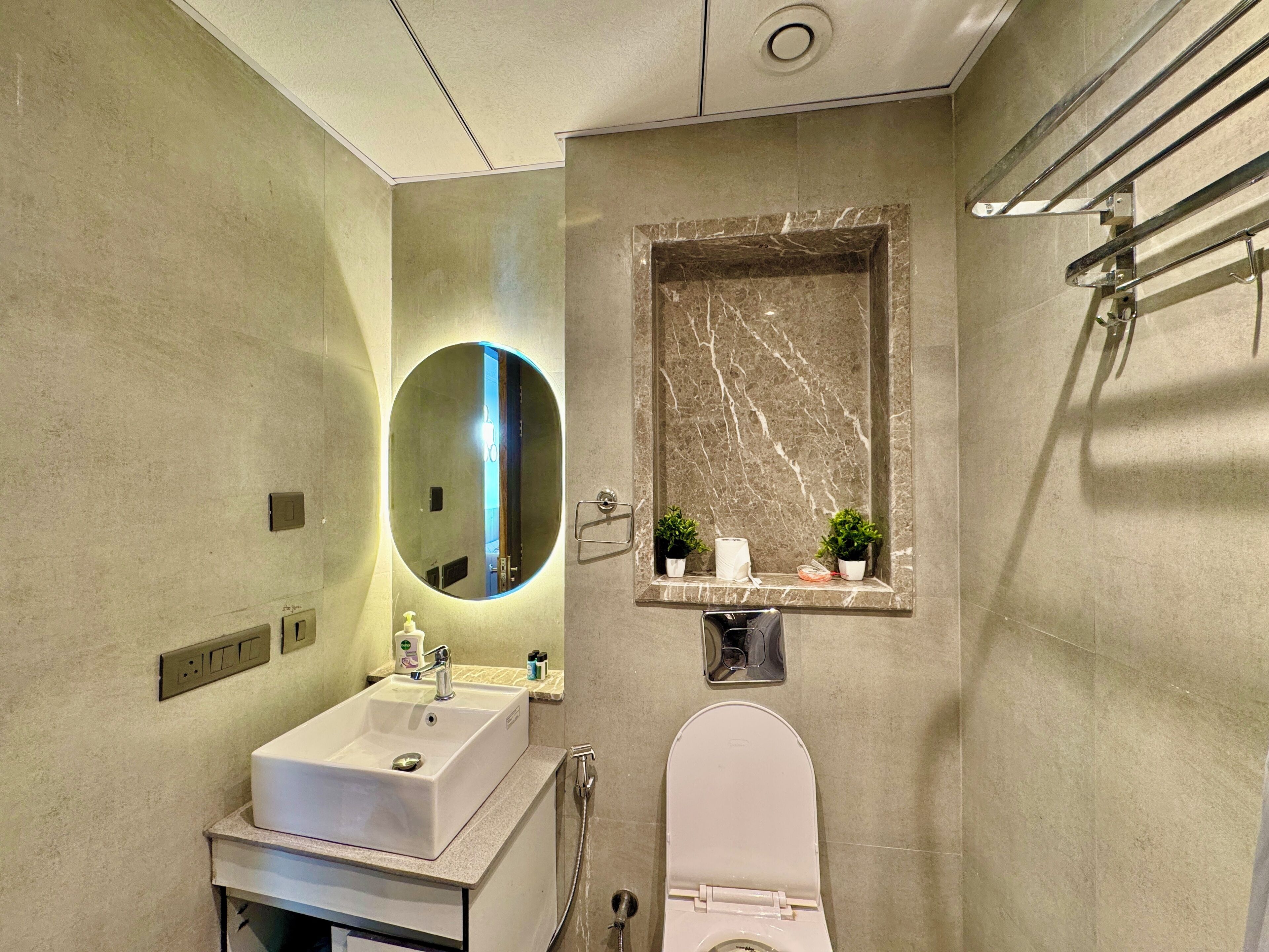 Ein modernes Badezimmer mit Waschbecken, Spiegel, Toilette und Dusche.