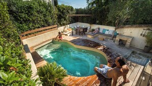 A backyard with a swimming pool, wooden deck, and outdoor seating area. - Charming house in camargue private heated pool jacuzzi (Vauvert)