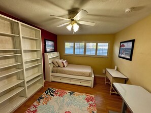 A bedroom with a bed, a wardrobe, a desk, and a ceiling fan. - The Stillwater - Pool, Riverfront & Viewing Dock - Close to Speedway & Downtown! (Daytona Beach)