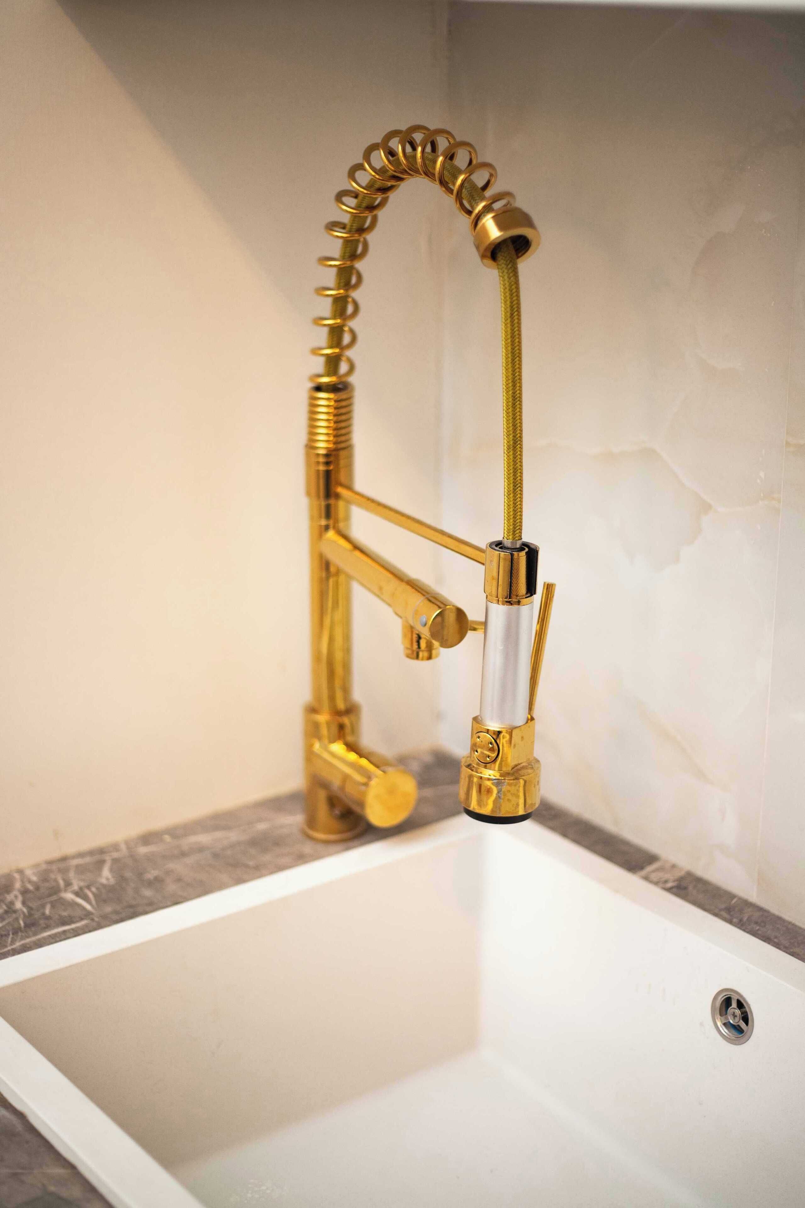 Une salle de bain avec un robinet doré et une baignoire blanche.