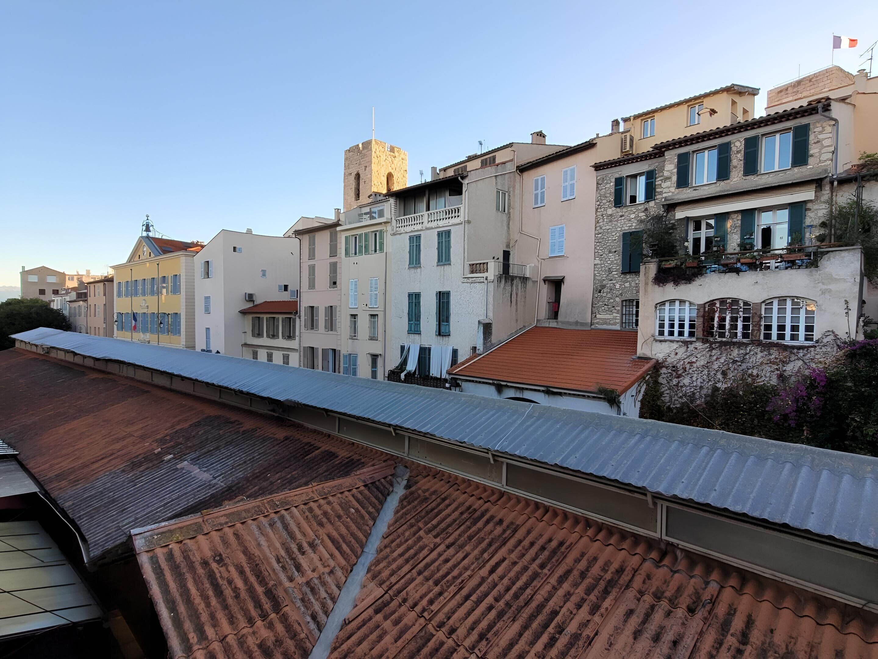 Une rangée de bâtiments présentant un mélange de styles architecturaux, dont une tour et un bâtiment doté d’une façade en pierre.