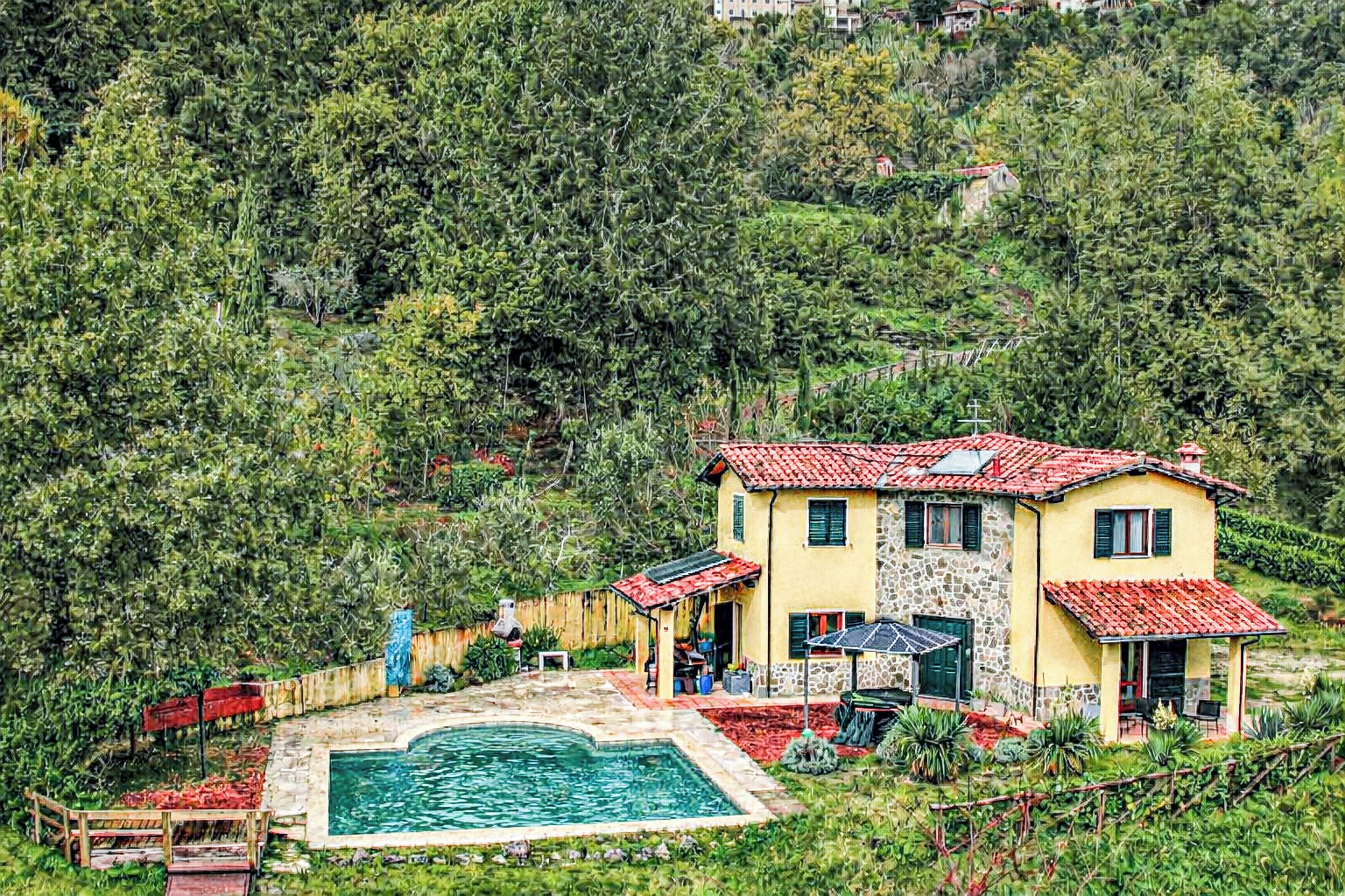 A two-story house with a swimming pool, surrounded by lush greenery and hills.
