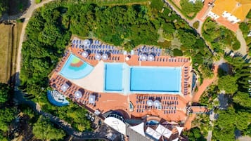 Vue aérienne d’un complexe hôtelier doté de plusieurs piscines, de chaises longues et d’un vaste espace paysager.