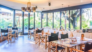 A restaurant with large windows, wooden tables, and chairs. - Riva degli Etruschi Villa Ansonica 3 beds (San Vincenzo)