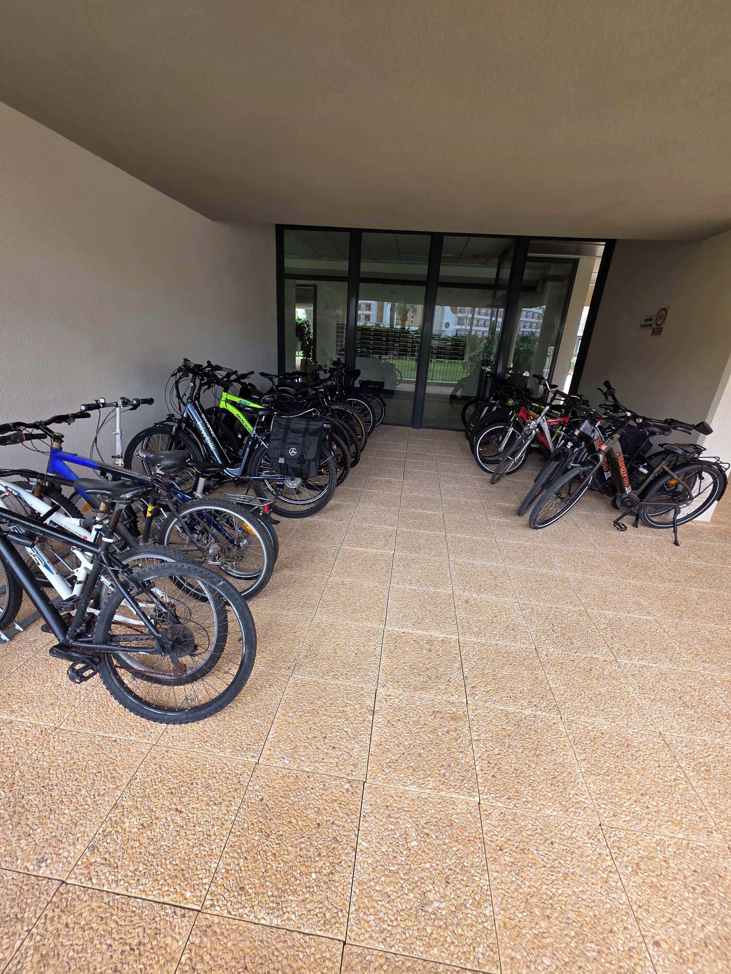A covered bike parking area with multiple bicycles.