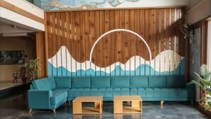 A modern lobby with a teal sofa, wooden panel wall, and a marble ceiling mural. - Yashi Homestay Jaipur: A Peaceful Retreat in the Pink City (Jaipur)