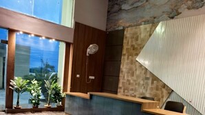 A spacious lobby with a marble floor, a reception desk, and a large window offering a view of the outdoors. - Yashi Homestay Jaipur: A Peaceful Retreat in the Pink City (Jaipur)