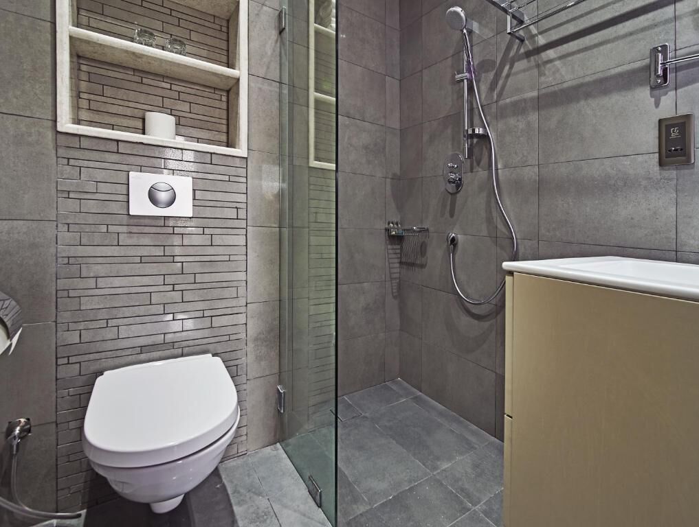 Ein modernes Badezimmer mit Toilette, Dusche und einer gläsernen Duschkabine.