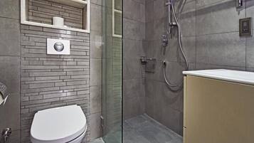 Ein modernes Badezimmer mit Toilette, Dusche und einer gläsernen Duschkabine.