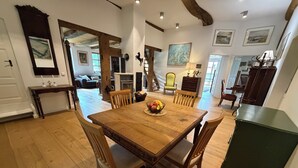 Ein Essbereich mit Holztisch und Stühlen, einer Obstschale und Blick in das Wohnzimmer.