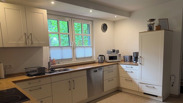A modern kitchen with a dishwasher, microwave, and stove.