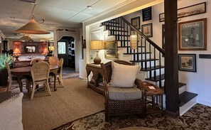 Ein gemütliches Wohnzimmer mit Essbereich, Treppe und Bücherregal.