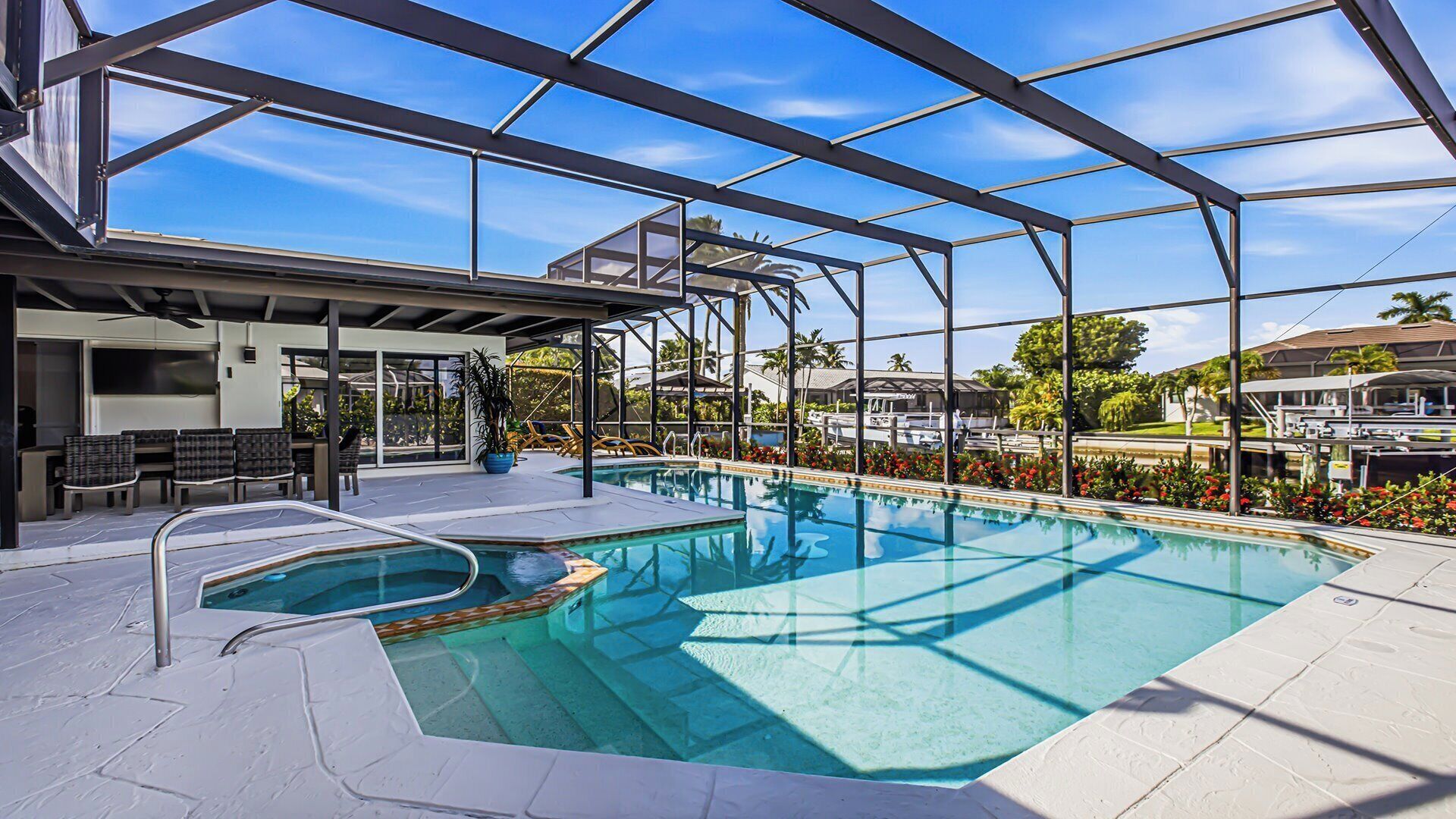 An indoor swimming pool with a clear view of the surrounding area, including a covered seating area and a poolside bar.