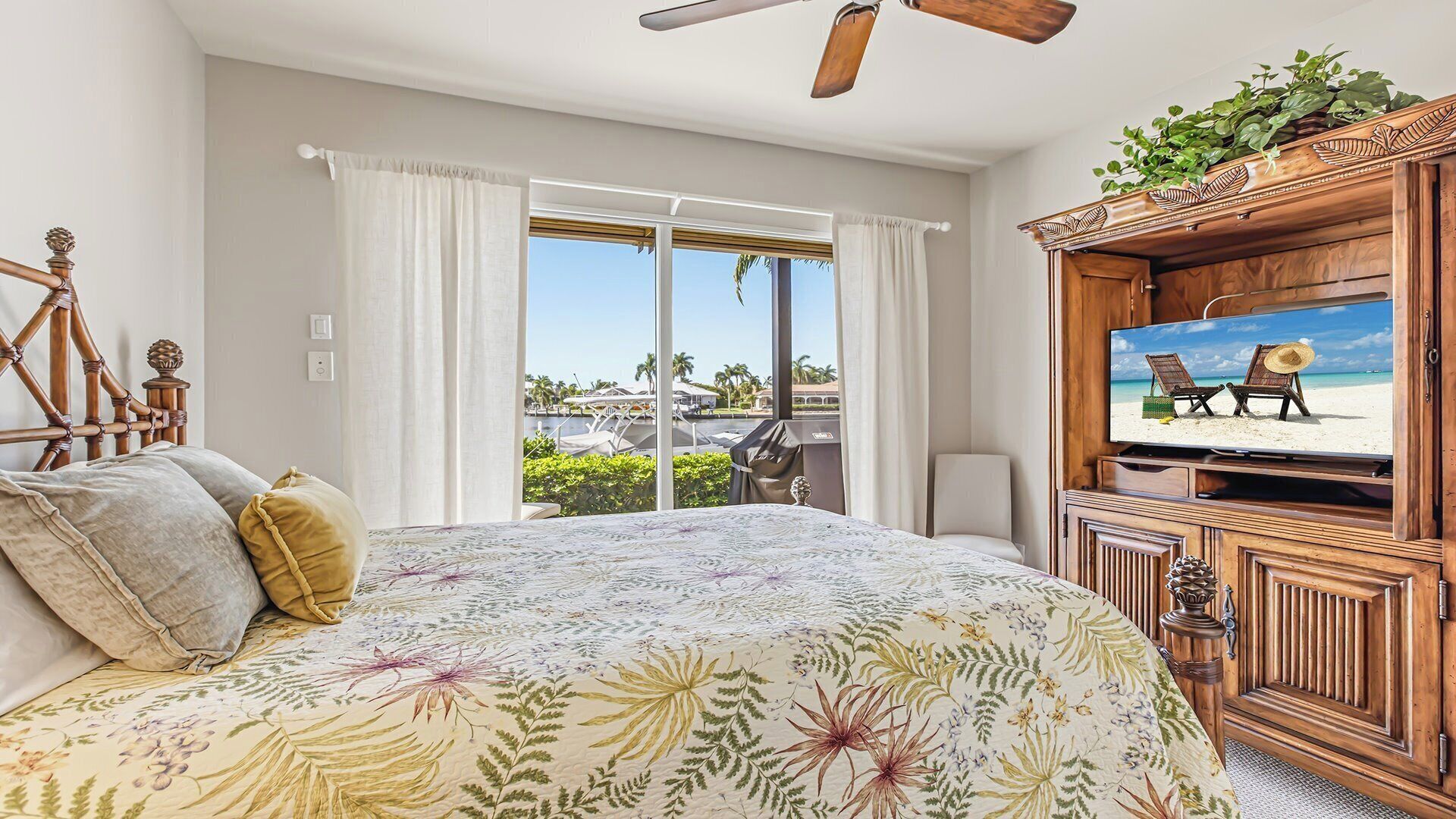 A bedroom with a bed, a television, and a view of a marina.