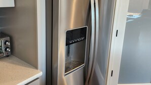 A stainless steel refrigerator with a water dispenser, a toaster, and a wooden floor. - Casa Limpia Tucson! (Tucson)