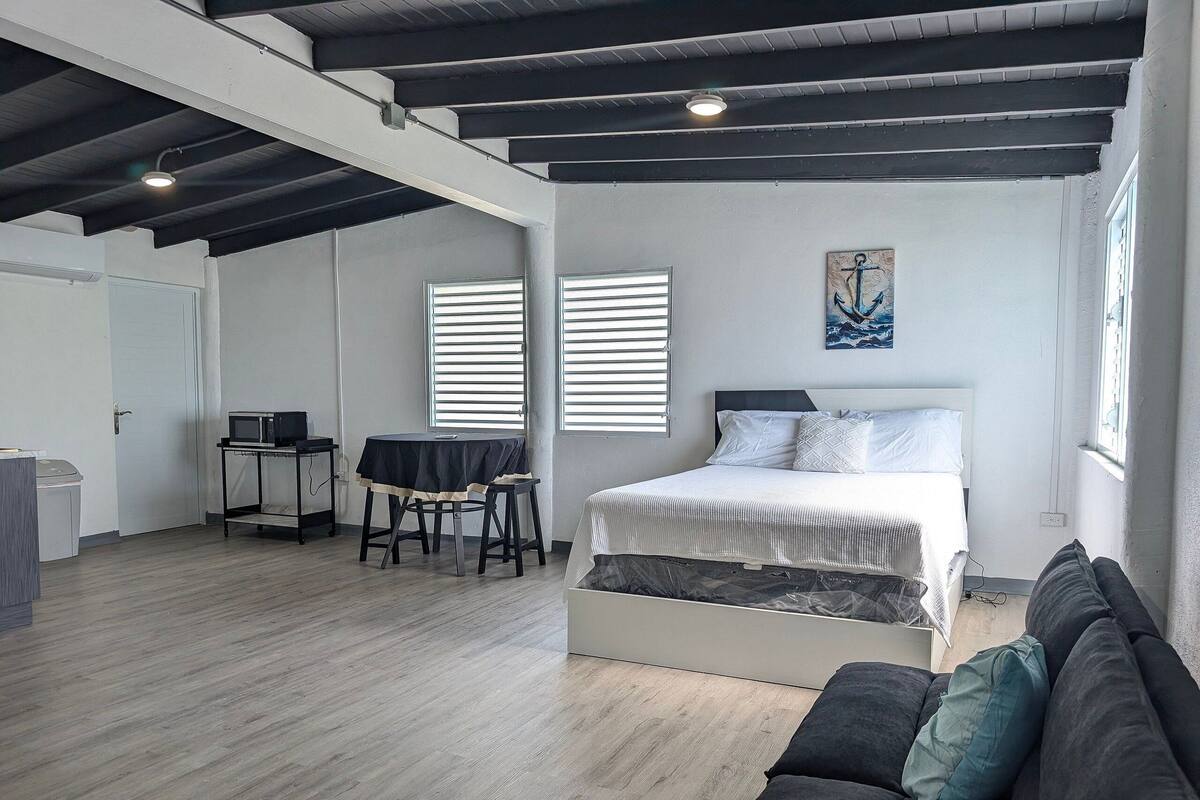 A modern room with a bed, a desk, and a couch.