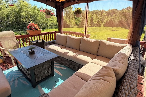Enjoy day or night in the lit gazebo with cozy oversized seating and fire pit