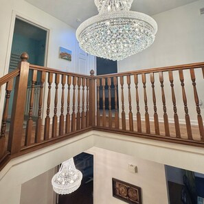 Eine Holzt Treppe mit einem Chandelier.