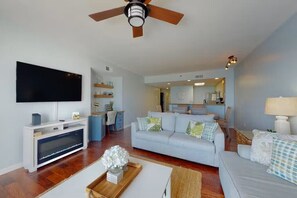 A modern living room with a flat-screen TV, a ceiling fan, and a light-colored sofa with decorative pillows. - Rates reduced, shorter stays welcome! Gulf front amazing views. (Destin)