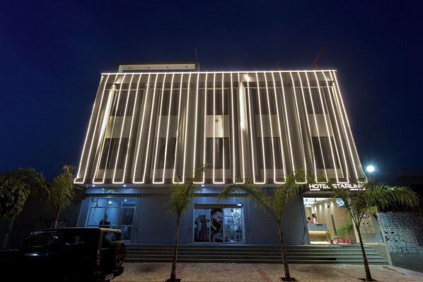 A modern hotel with a prominent vertical light strip design, a visible entrance, and a sign reading "HOTEL STARLINK." - Hotel Starlink By The Nine Hotel  (Jaipur)
