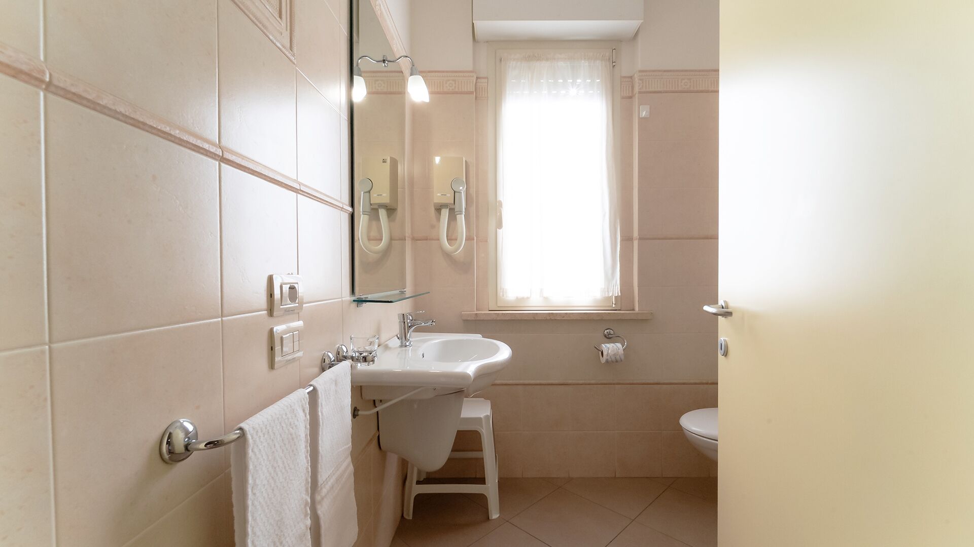 Ein Badezimmer mit Waschbecken, Spiegel und Toilette.