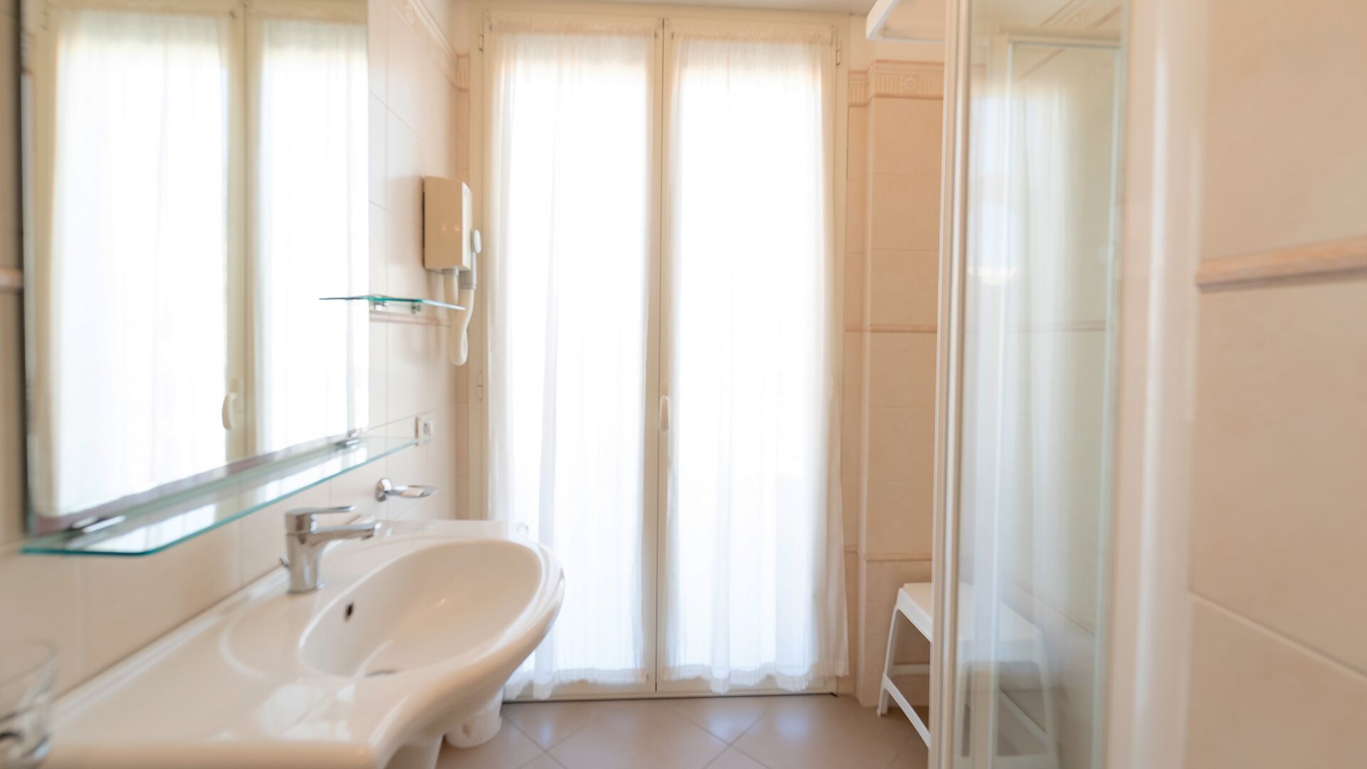 A modern bathroom with a toilet, bidet, and glass shower enclosure.