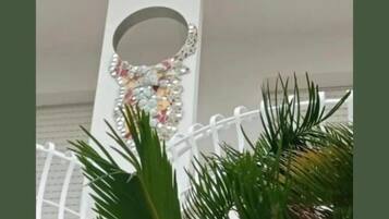 A white railing with a decorative mirror and a wall-mounted mirror.