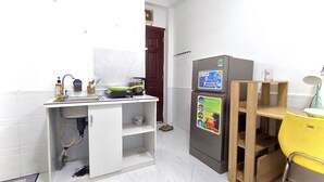 Eine kleine Küche mit Spüle, Herd und Kühlschrank, an dem Magnete hängen.