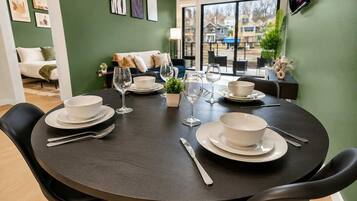 A dining area with a round table set for four, chairs, and a view of the outside.