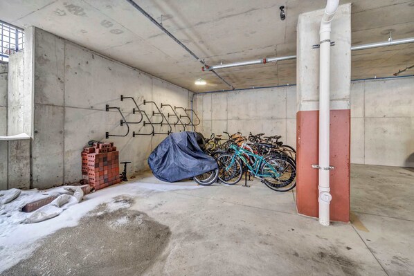 A parking garage with concrete walls, a blue tarp, and a bicycle.