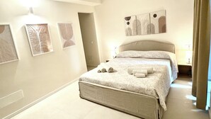 Ein geräumiges Schlafzimmer mit einem großen Bett, einem Nachttisch und Wandbildern.