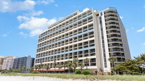 A multi-story hotel with a modern design, featuring numerous balconies and a beachside location. - Family-Friendly Oceanfront Room with Balcony – Steps from Ripley’s Aquarium (Myrtle Beach)