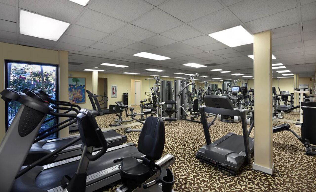 A gym with treadmills, elliptical machines, and weight equipment.