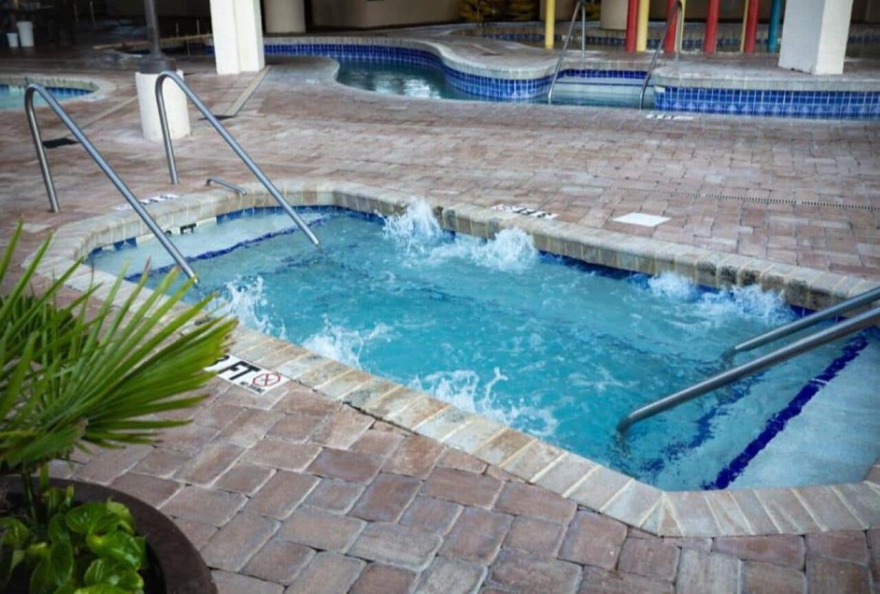 A hot tub area with a tiled floor and metal railings.