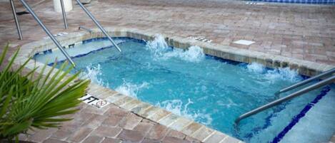 A hot tub area with a tiled floor and metal railings.