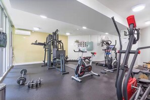 A gym with exercise equipment, a stationary bike, and dumbbells. - Stylish 2 BDR Apt Near QUT And RBWH With Parking (Kelvin Grove)